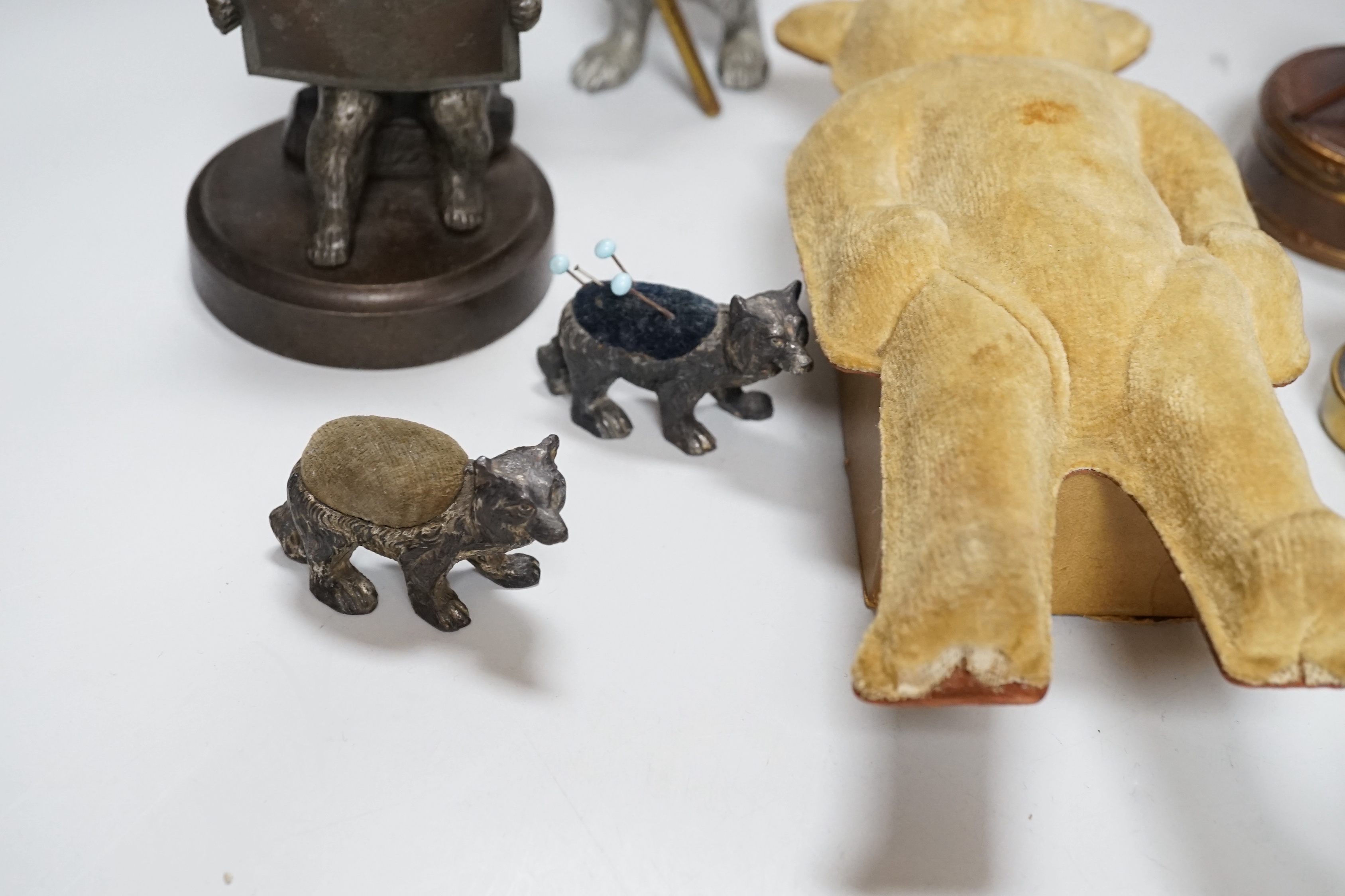 Four metal bear pin cushions, a money box, a bear stud box, three metal bears, a mother of pearl metal bear dish and an advertising bear on a box